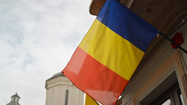 The Romanian flag waving on a building in the Old Town of Bucharest