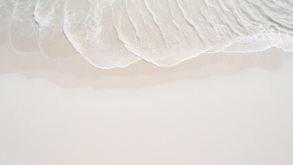 top view of waves on the edge of a white sand beach with texture as a background.