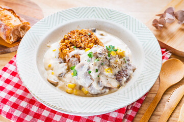 カレー飯に乗せた煮込みハンバーグ