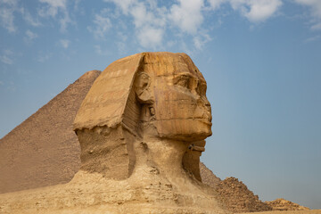 Beautiful profile of the Great Sphinx including pyramids of Menkaure and Khafre in the background on a clear sunny, blue sky day in Giza, Egypt