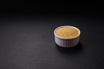 Wheat porridge couscous grains on a dark concrete background