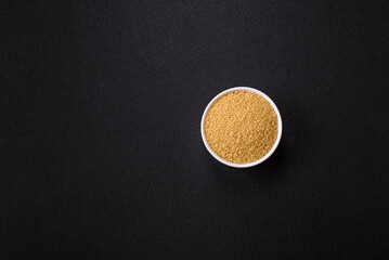 Wheat porridge couscous grains on a dark concrete background
