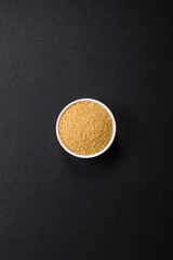 Wheat porridge couscous grains on a dark concrete background
