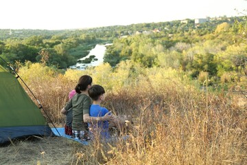 Family enjoying picturesque view near camping tent