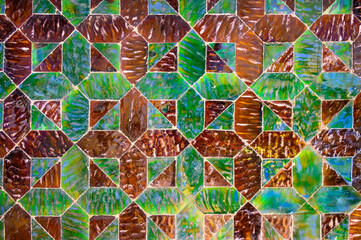 Fototapeta premium Multicolored background of antique glossy tiles of different shapes, arranged in a certain order and pattern