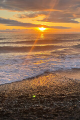 Sunset over the water with birds flying against sunlight on the Sea