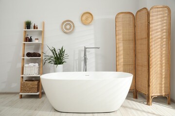 Stylish bathroom interior with folding screen and tub