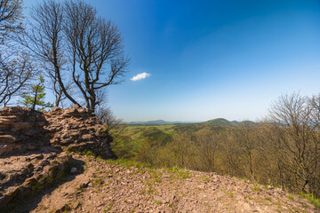 Beautiful green landscape of Walbrzych mountains with blue sky seen from top of Rogowiec mountain 870 meters above the sea level with ruins of old castle