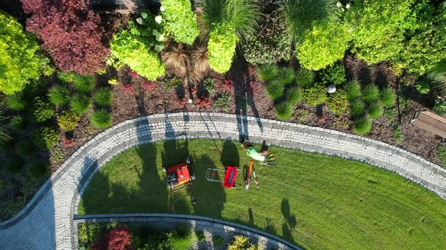 Aerial View of a Vibrant Garden and Landscaping Worker with His Equipment.
