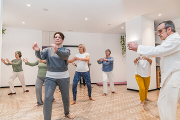 A group of people are practicing Tai Chi in a room