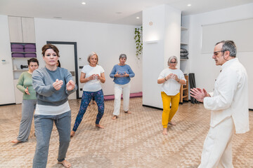 Group of senior women performing yoga poses in class, focusing on balance and harmony