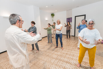 Fototapeta premium Yoga instructor guiding a group of senior women in a wellness and balance exercise