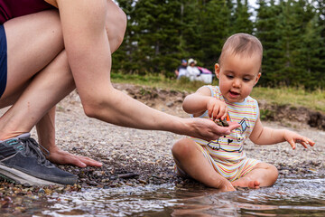 Baby Exploring Nature with Parent by a Stream in Waterton, Alberta, Canada