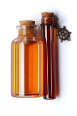 Top-down view of a round glass bottle filled with dark orange essential oil and a glass vial containing dark amber oil for cosmetics and natural medicine.