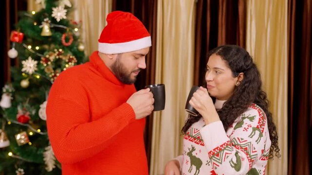 Indian Couple Drinking Coffee and Talking with Christmas Tree in background