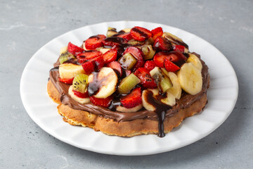 Fruit waffles, bananas with chocolate sauce, strawberries, chocolate chips, handmade Turkish waffles with pistachio