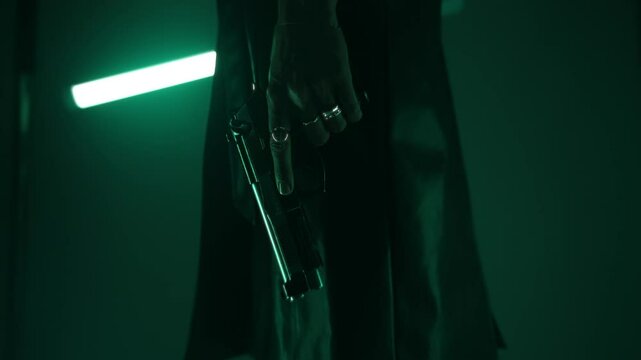 Woman agent in a leather coat holding an m9 handgun in a dark room lit by led lamps