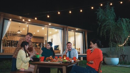 Family together celebrate anniversary in garden. Senior give gift to granddaughter. Outdoor camping activity to relax with relatives, spend time with multigeneration cross generation gap. Divergence.