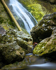 A waterfall in the forrest valley in early autumn
