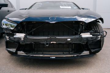 Close-up of disassembled car without bumper at service station. Repair auto after accident, parts...