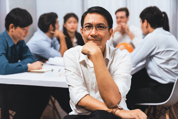 Engineer team leader portrait with diverse group of civil engineer and client working together on architectural project, reviewing construction plan and building blueprint at meeting table. Prudent