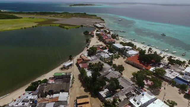 Aerial drone view of small airplane landing at Los Roques airport runway, Gran Roque Venezuela