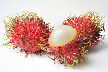 Close up photograph of a rambutan fruit on white background. Healthy eating, natural sugars, tropical fruits. Rambutan is a source of vitamin C, fibre, several vitamins and minerals. 