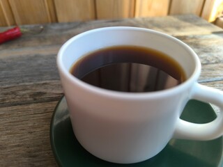 white cup of coffee on a green saucer. High-quality photos