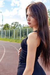 A beautiful athletic girl stands at the stadium.