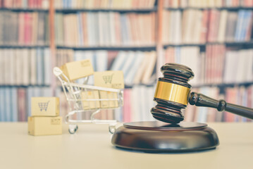 Consumer protection law, rights and guarantees, justice concept : Judge gavel, a shopping cart with goods boxes, depicting a safeguard designed to protect buyers from fraudulent business practices.
