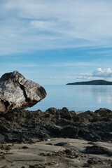 A big piece of driftwood on the beach of a small island of Fiji. Large piece of deadwood with small islands in the background. Lonesome beach scene in Fiji. 