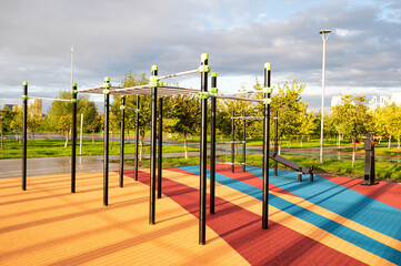 Fototapeta premium An empty sports ground with exercise equipment equipped for outdoor training in the park. Sports and recreation area in the city park