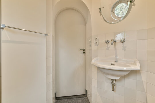 Compact and bright white-tiled bathroom interior