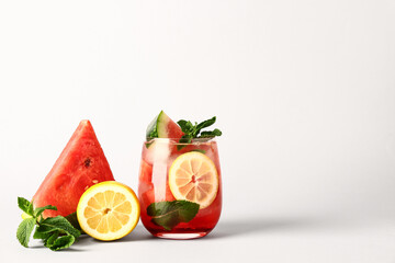 Glass of fresh watermelon lemonade with mint on white background
