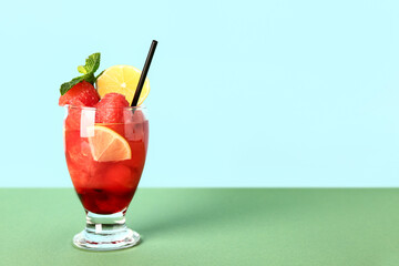 Glass of fresh watermelon lemonade with mint on green table