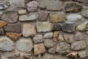 stone fence made of uneven gray and brown blocks close-up