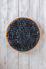 Blueberry tart on a white wooden background. Food photography.