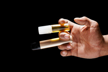 hand holding e-cigarette with refillable liquid on black background for copy space.