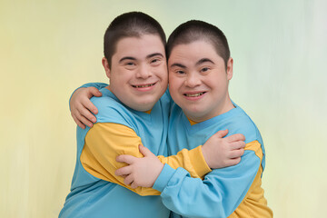 Obraz premium Two Down syndrome kids hugging each other while smiling into the camera