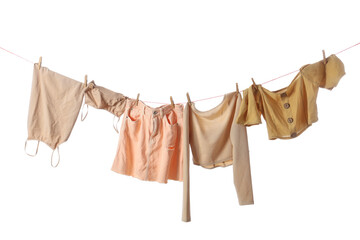 Stylish female clothes hanging on rope against white background