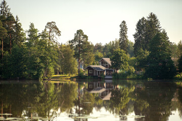 Obraz premium A house on the shore of a forest lake. Rest on the lake.A country house in nature.
