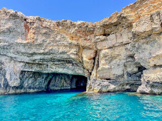 Clear and bright turquoise waters on a cliff cave in Gozo, Malta Island, Mediterranean Sea