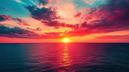 A vibrant sunset over the ocean, with the sun dipping below the horizon and colorful clouds overhead.