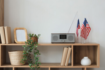 Wooden shelf with USA flags, radio and houseplant in living room
