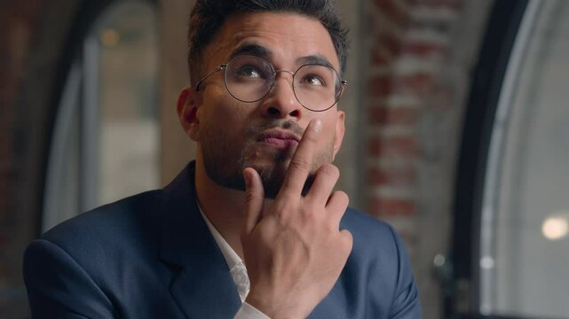 Thoughtful puzzled businessman Arabian Indian man thinking male guy employer worker think idea business plan strategy ponder consider doubt choose remember decide search deep thought question indoors