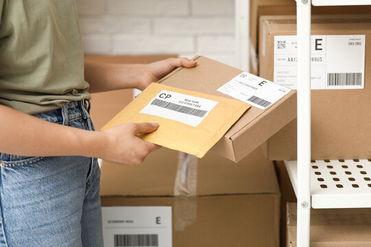 Woman with parcels at postal warehouse, closeup