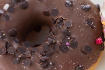 Close up on a donut resting on white background.