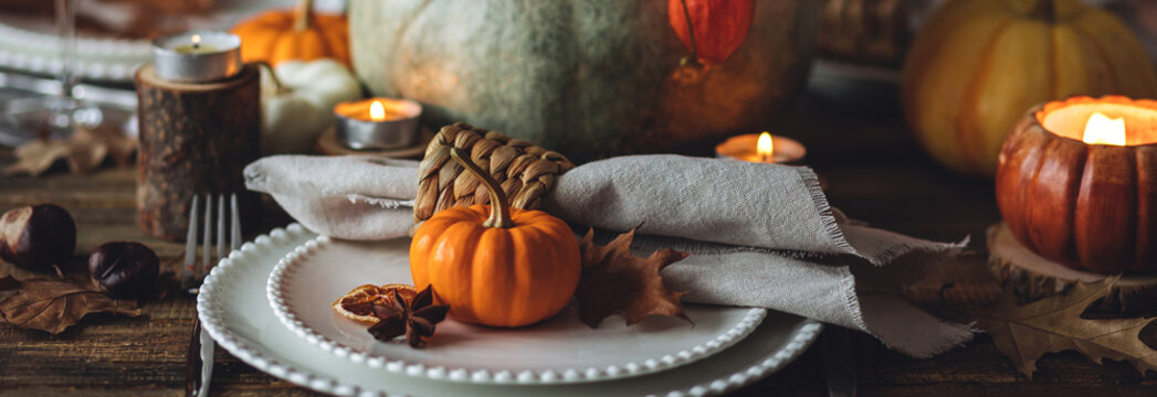 Fall table decoration with pumpkins, wine. Family cozy thanksgiving dinner arrangement indoors at home, wedding elegant decor. Countryside style, simple handmade setting, autumn mood banner