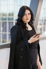 Confident Businesswoman with Smartphone in Modern Office Environment