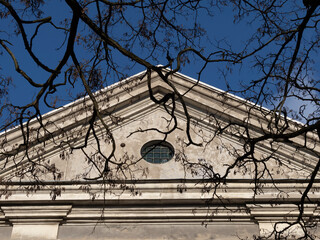 Attic of an old chapel and naked branches on front view.